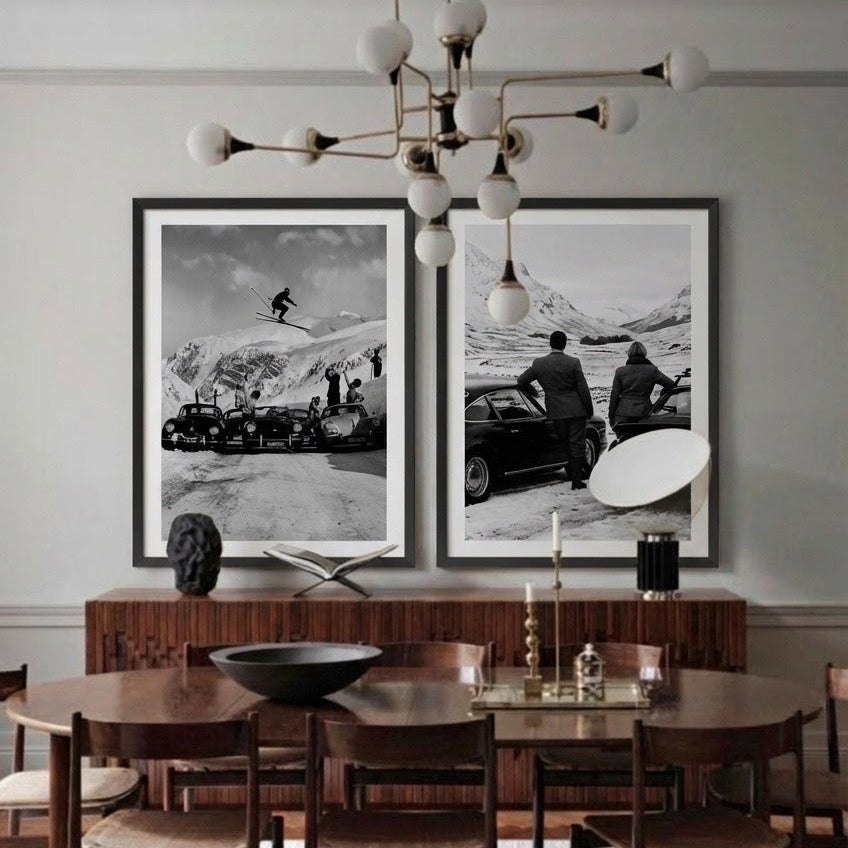 Dining room with framed black and white photos on the wall above a wooden table.