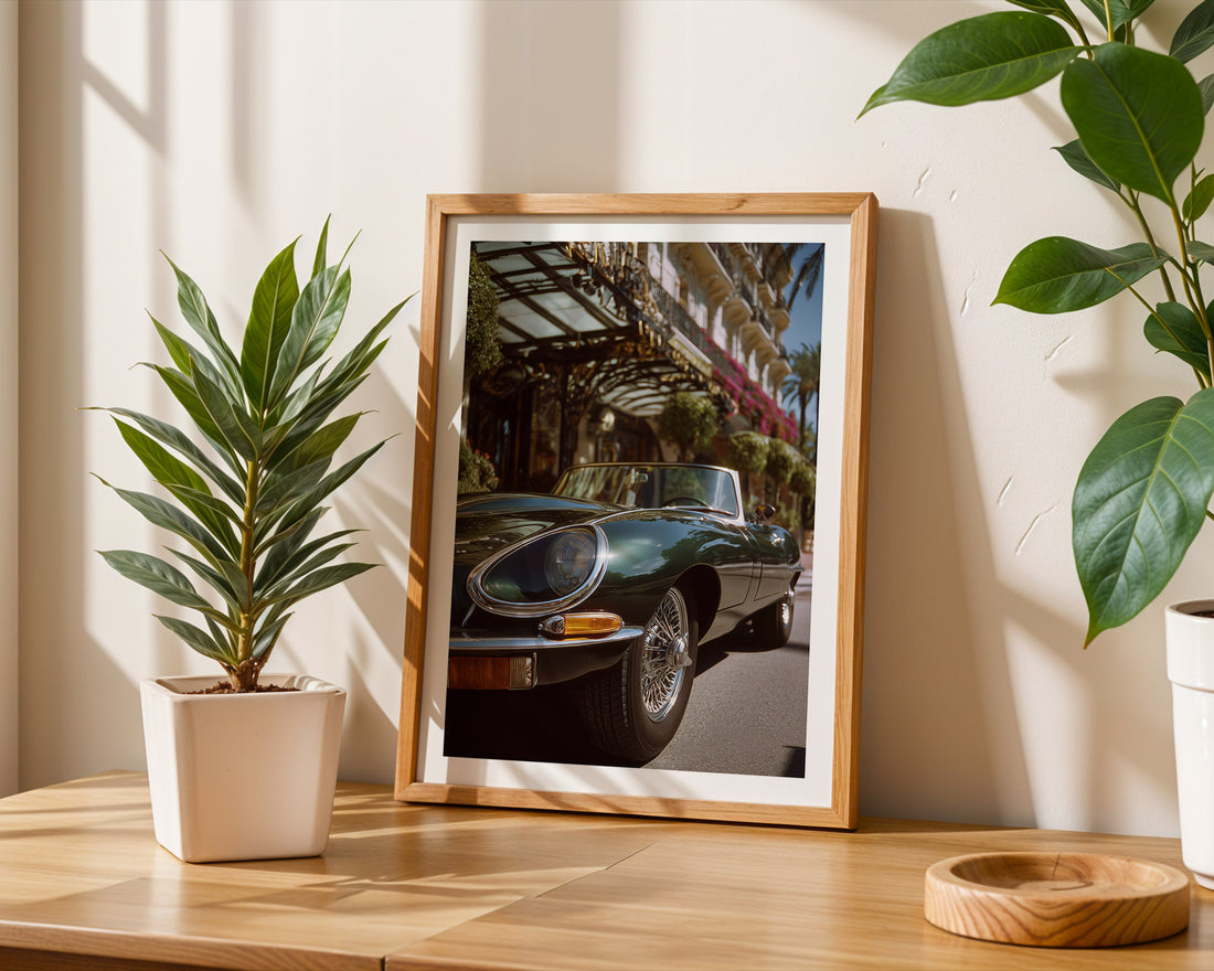 Framed photograph of a classic Jaguar e-type on a wooden table with plants