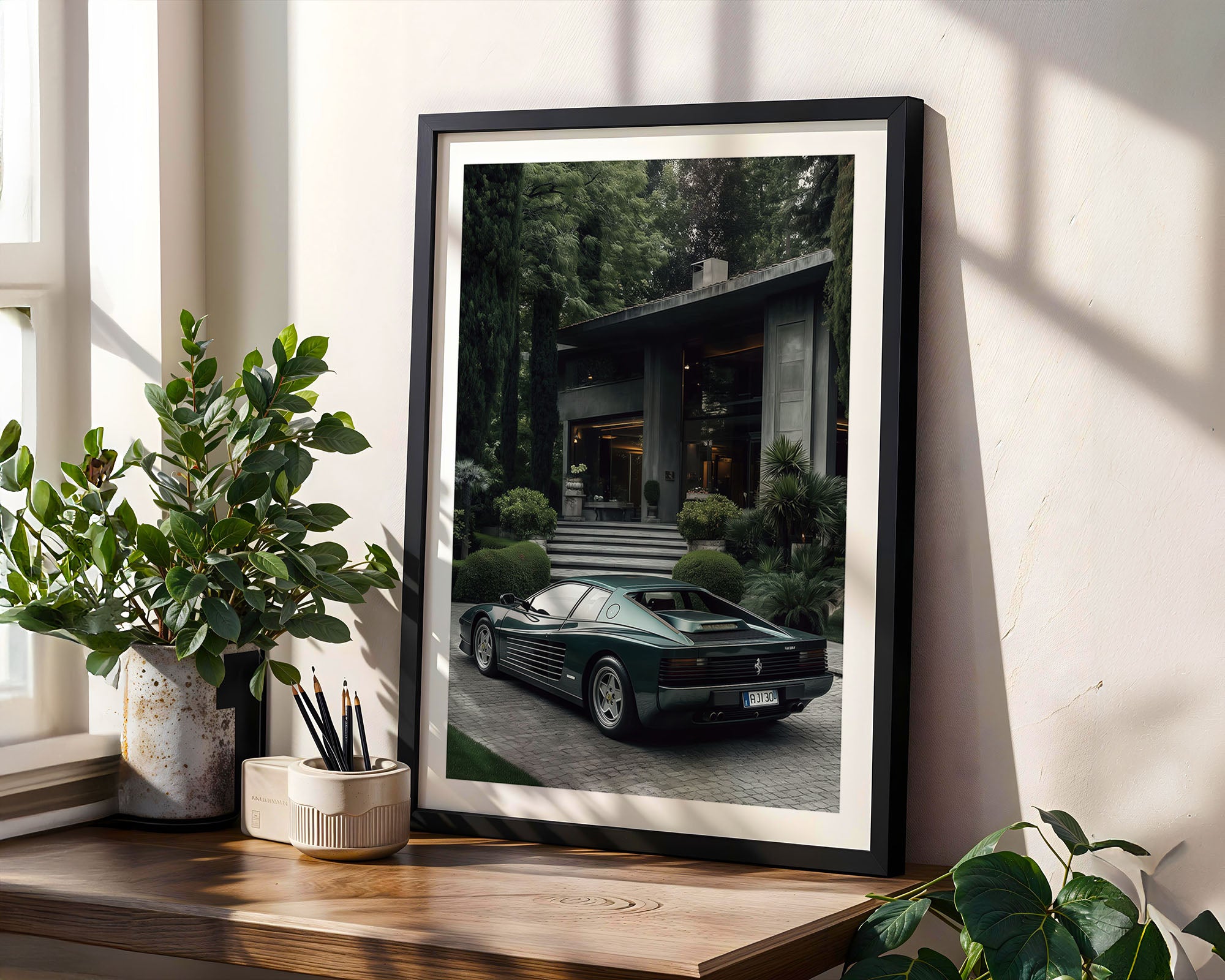Framed photograph of a green sports car on a wooden shelf with plants