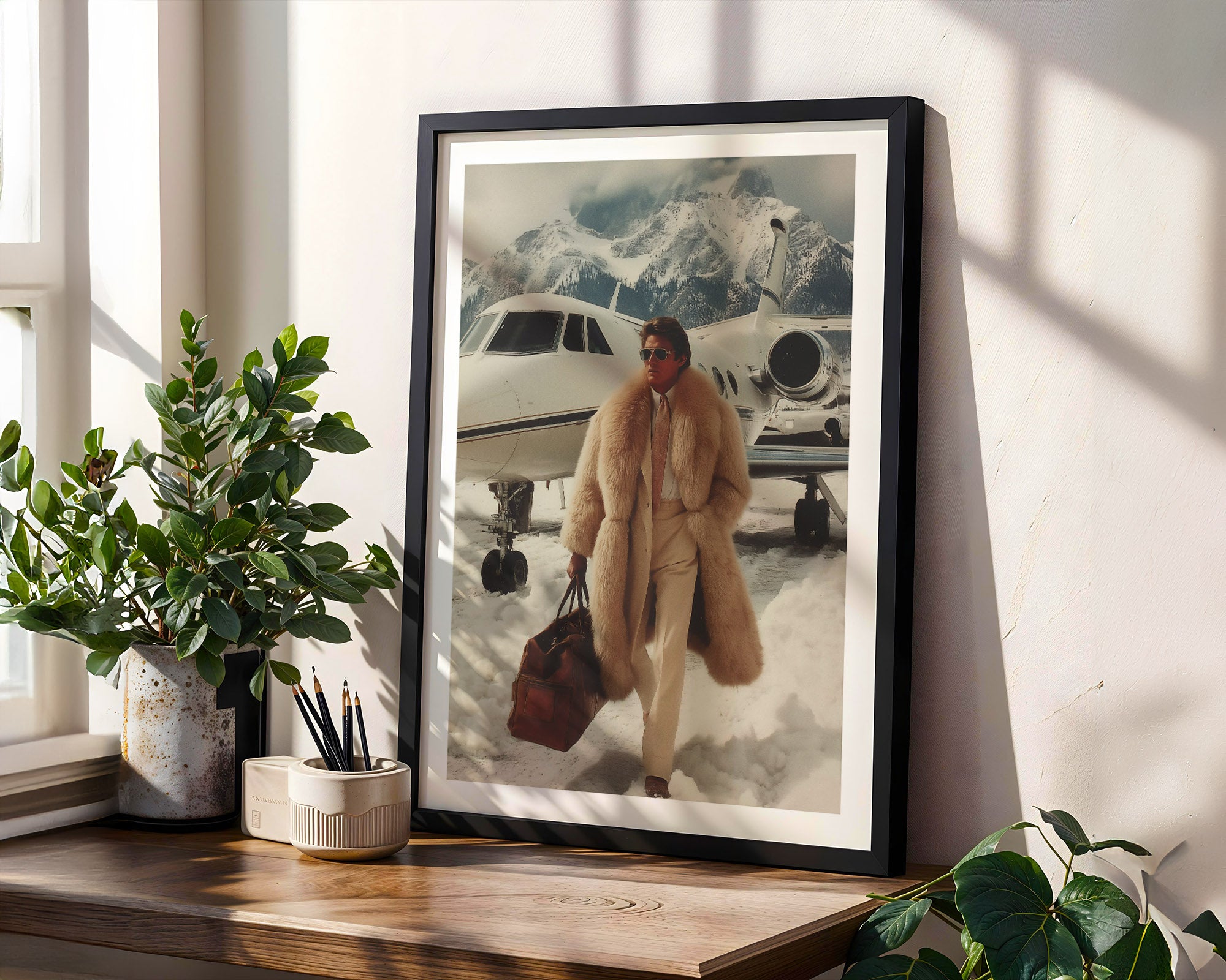 Framed artwork of a finance guy in a fur coat standing next to an airplane on a snowy mountain, placed on a wooden shelf with plants.