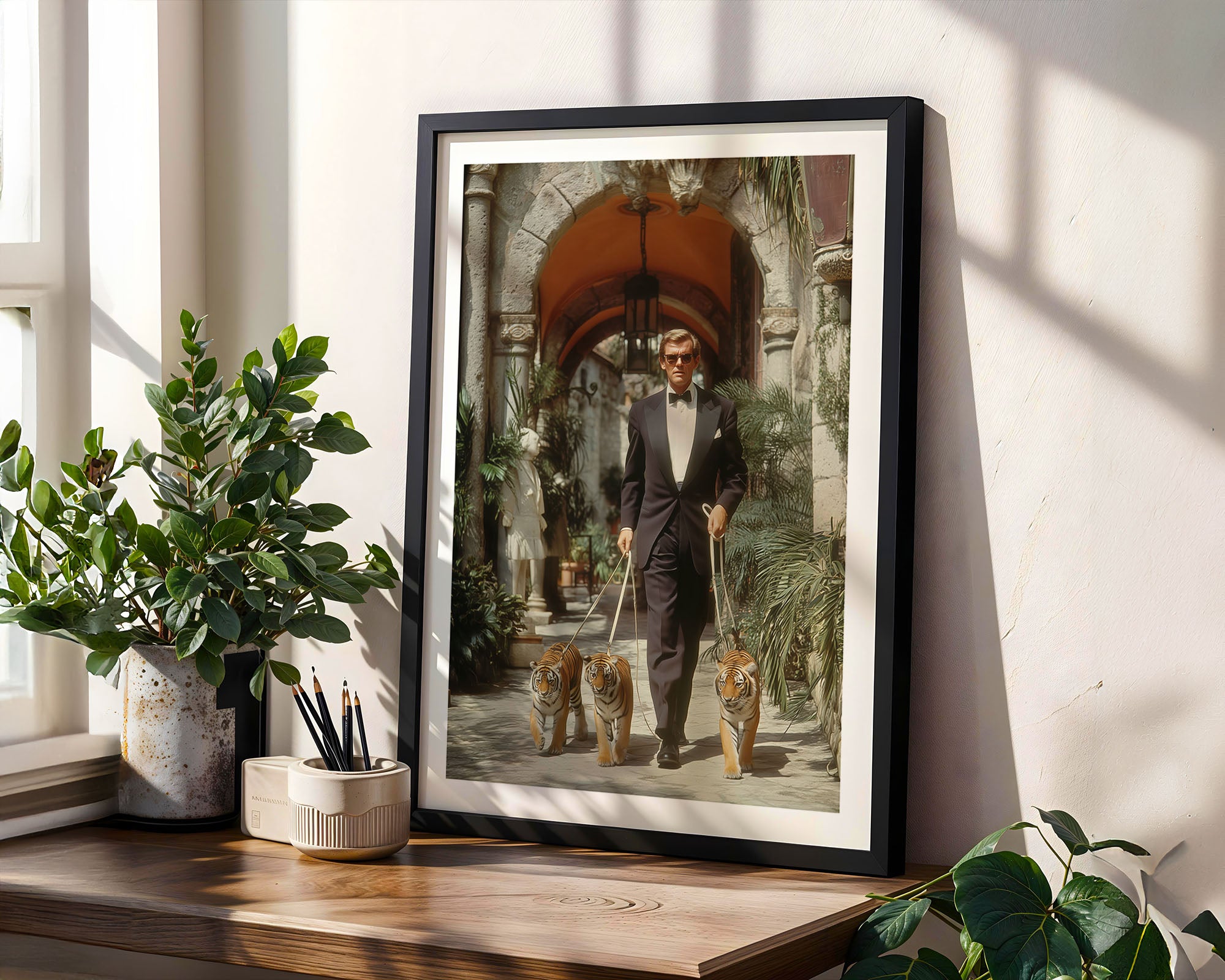 Framed artwork of a man with two tiger cubs on a leash in a decorative setting.