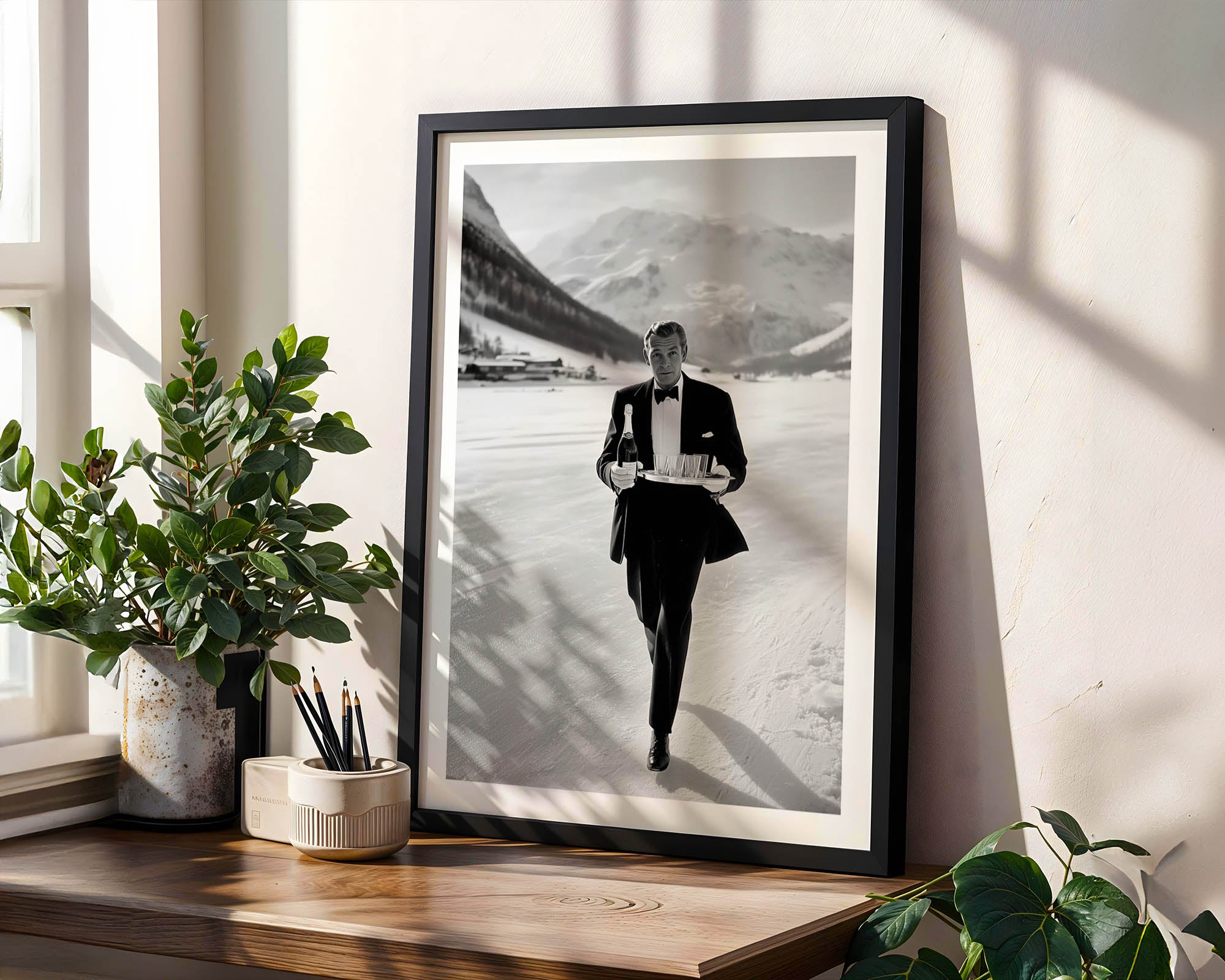 Framed black and white portrait of a man in formal attire walking in Gstaad on a wooden shelf with plants.