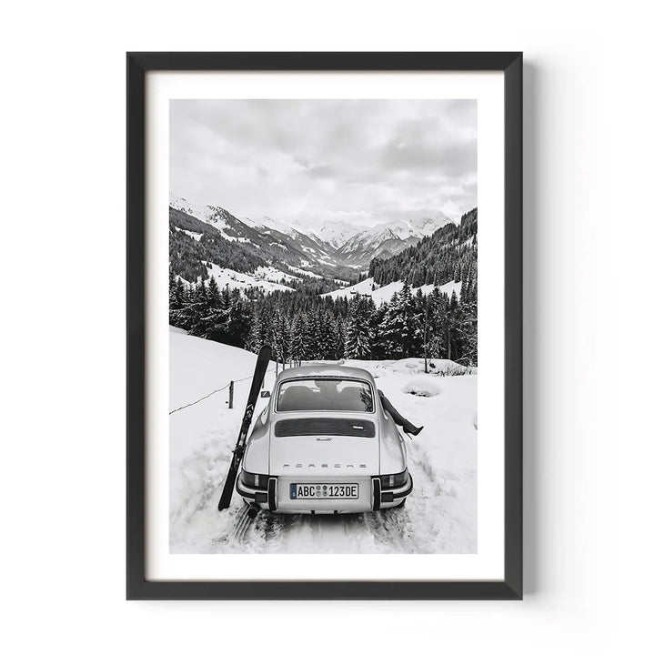 Framed black and white photograph of a vintage car in a snowy mountain landscape
