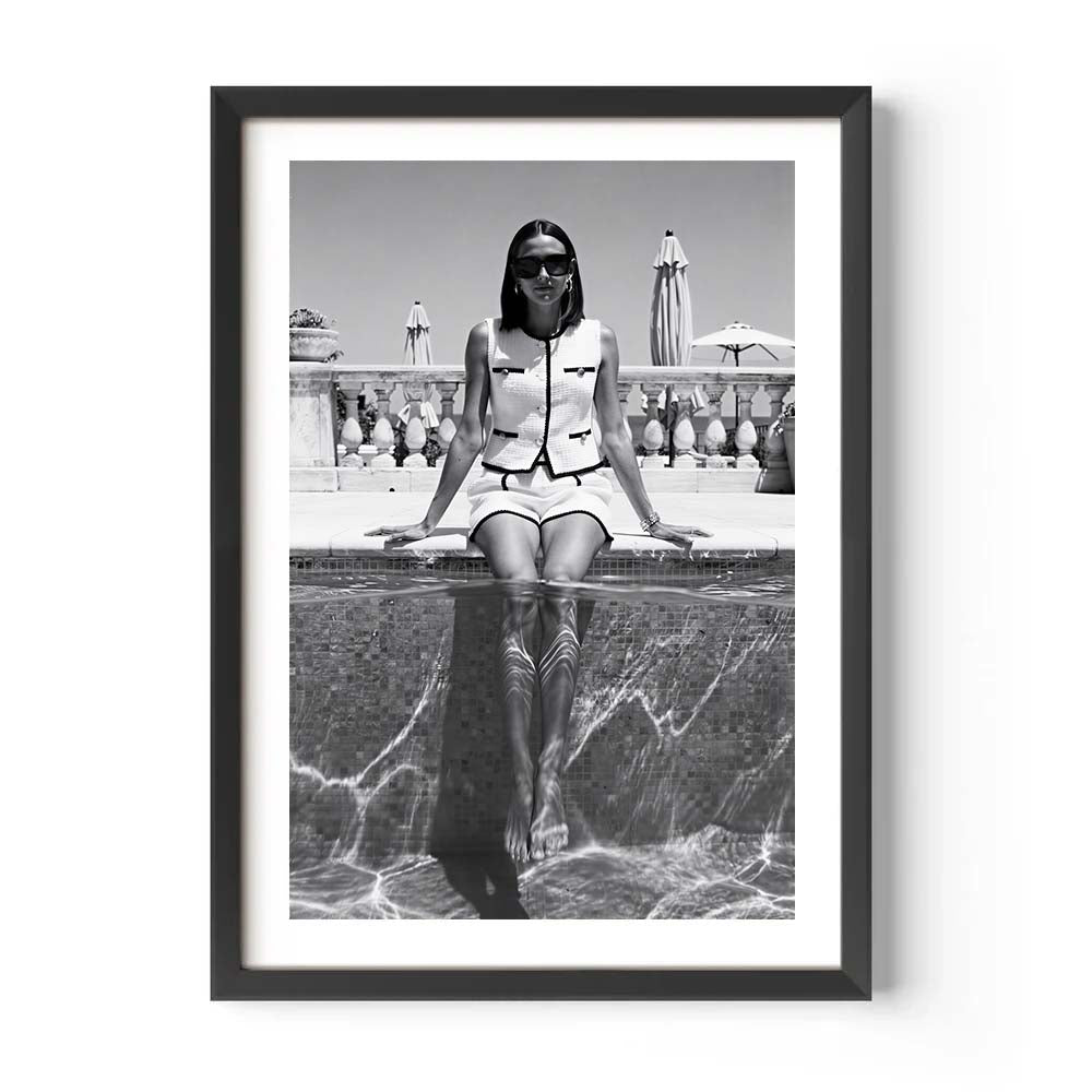 Framed black and white photo of a person sitting by a pool.