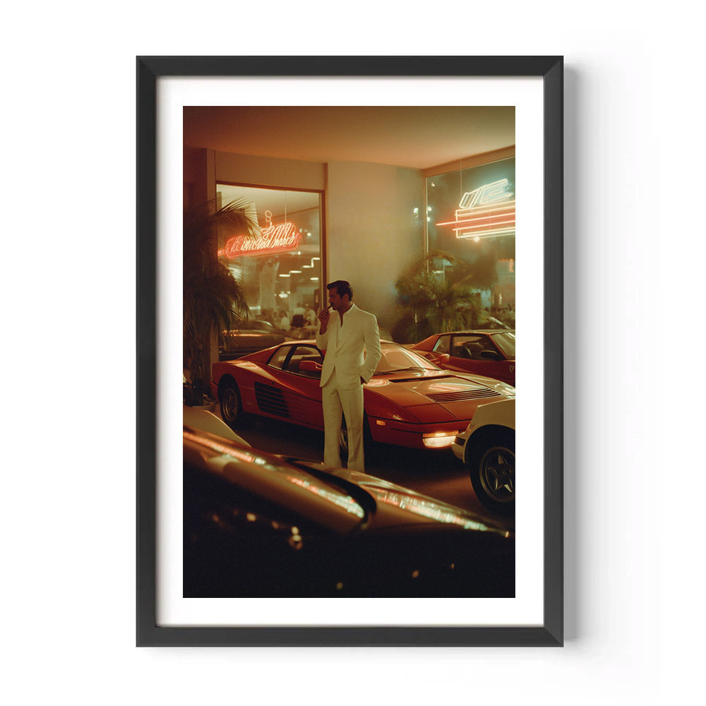 Framed photo of a man standing next to a red sports car in an urban setting with neon lights.