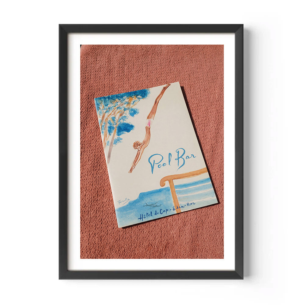 Framed poster of a swimmer and 'Pool Bar' text on a textured red surface from Hôtel du Cap-Eden-Roc