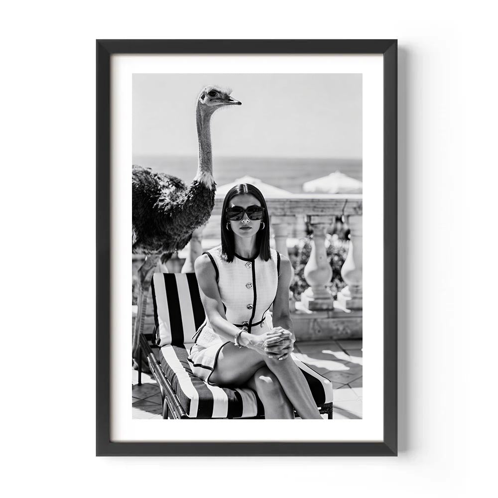 Framed black and white photo of a woman on a lounge chair with an ostrich