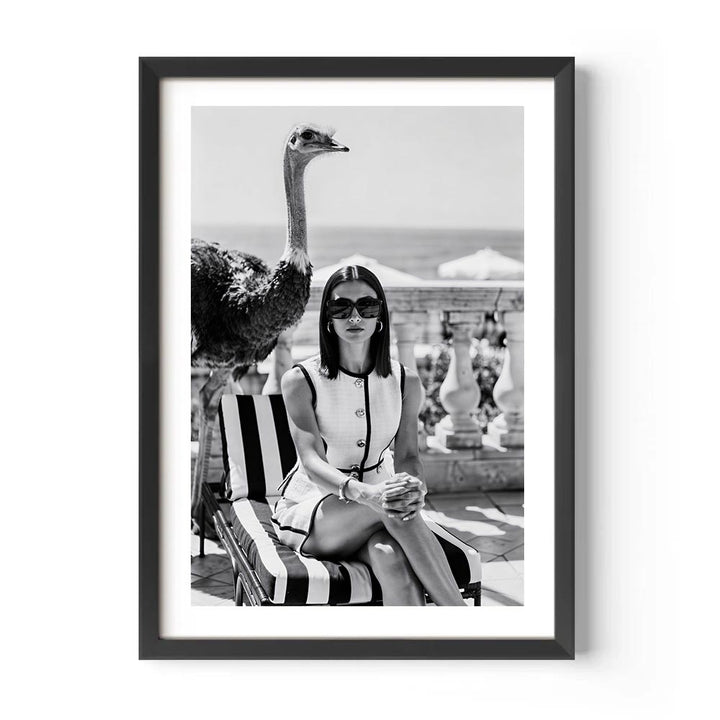 Framed black and white photo of a woman on a lounge chair with an ostrich