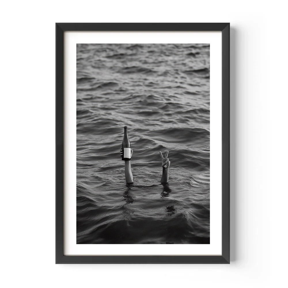 Framed black and white photograph of two poles in water