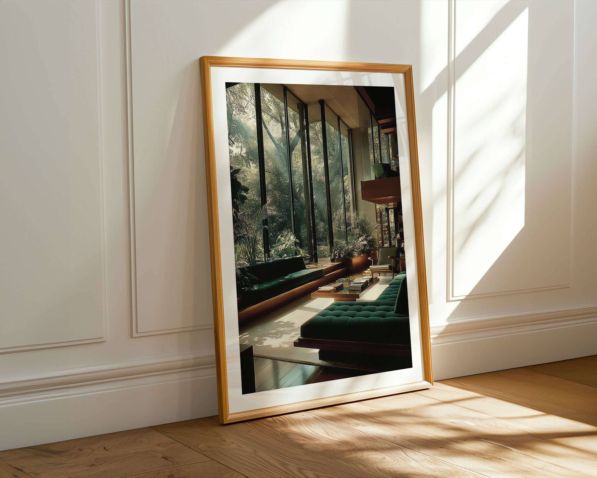 Framed mirror reflecting a room with green sofas and large windows.