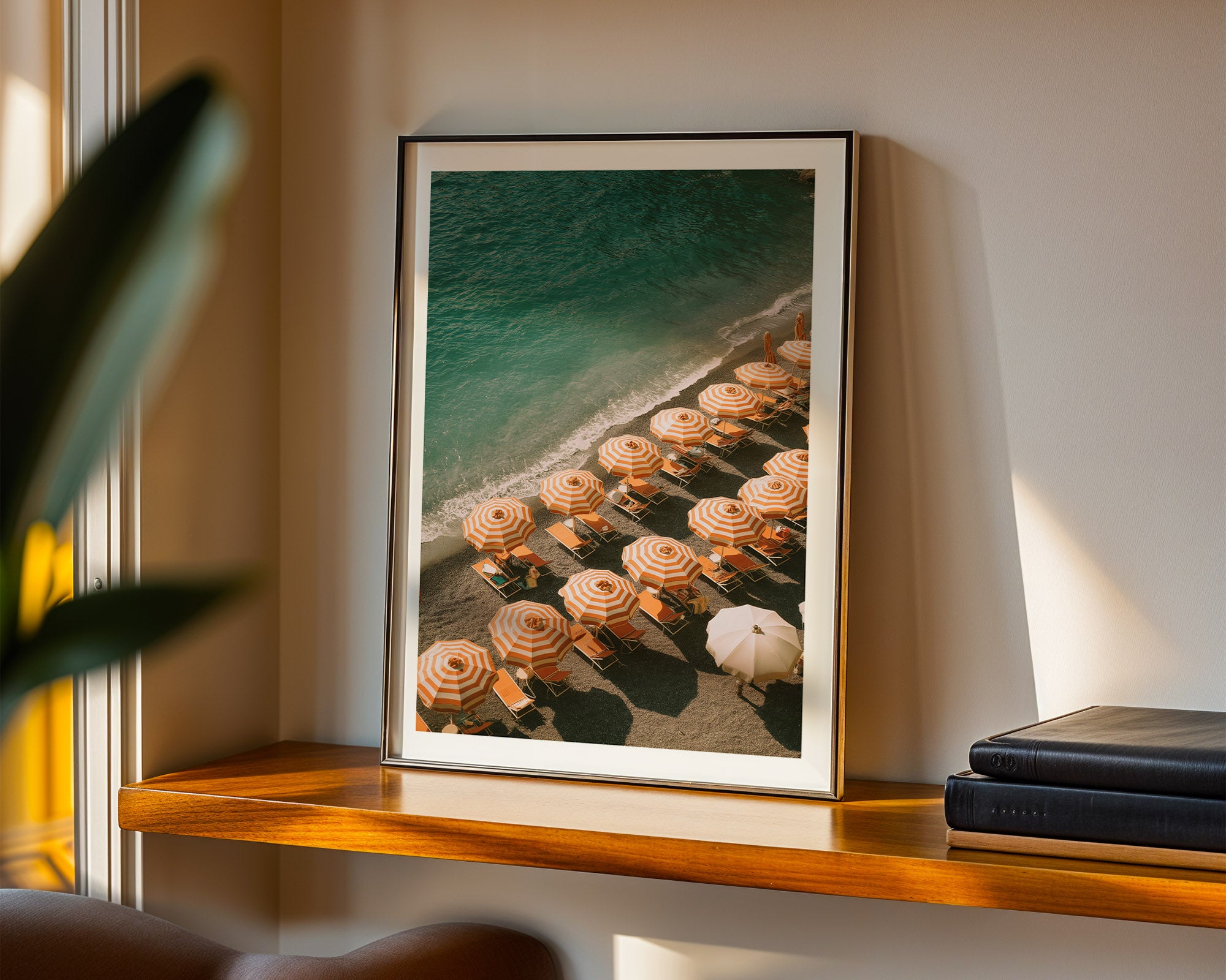 Framed beach scene with lounge chairs and umbrellas on a shelf.