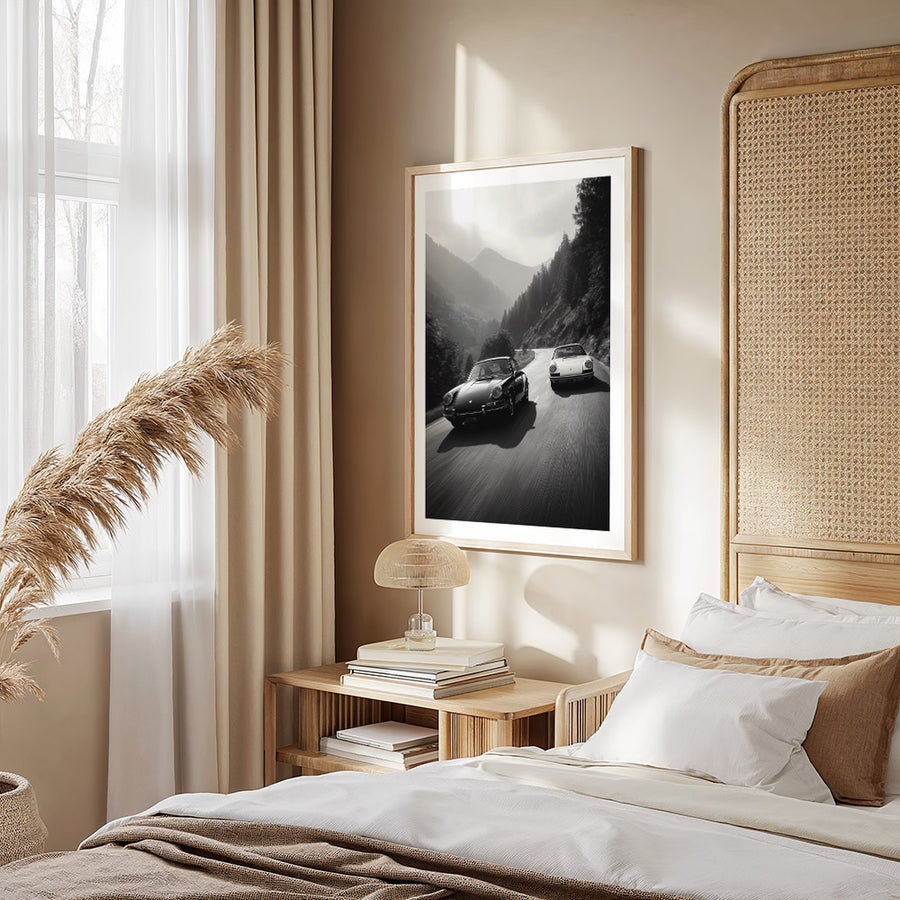 Modern bedroom with a framed photograph on the wall, bed with pillows, and side table.