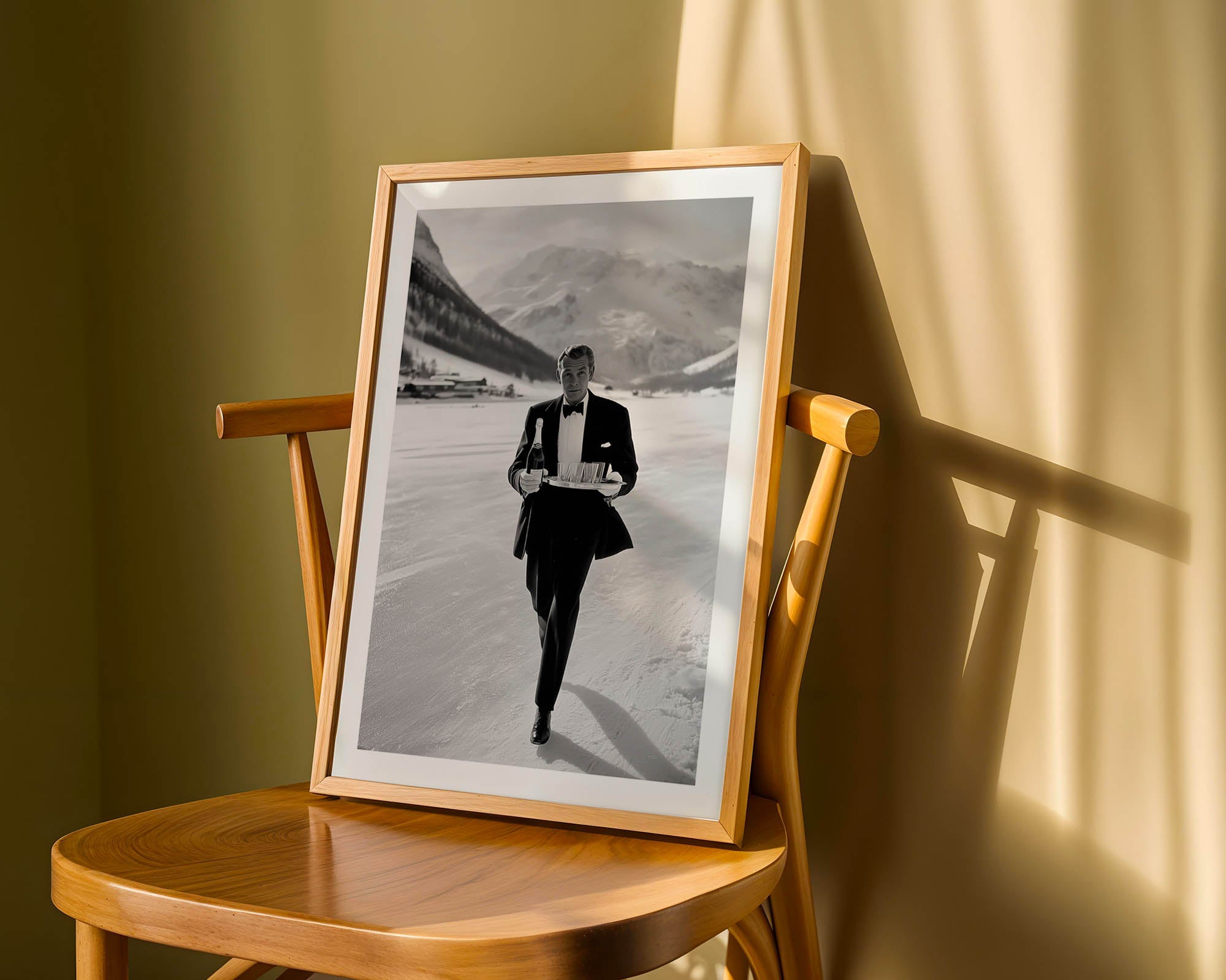 Framed black and white photo of a man in a suit on a wooden chair with a yellow wall background