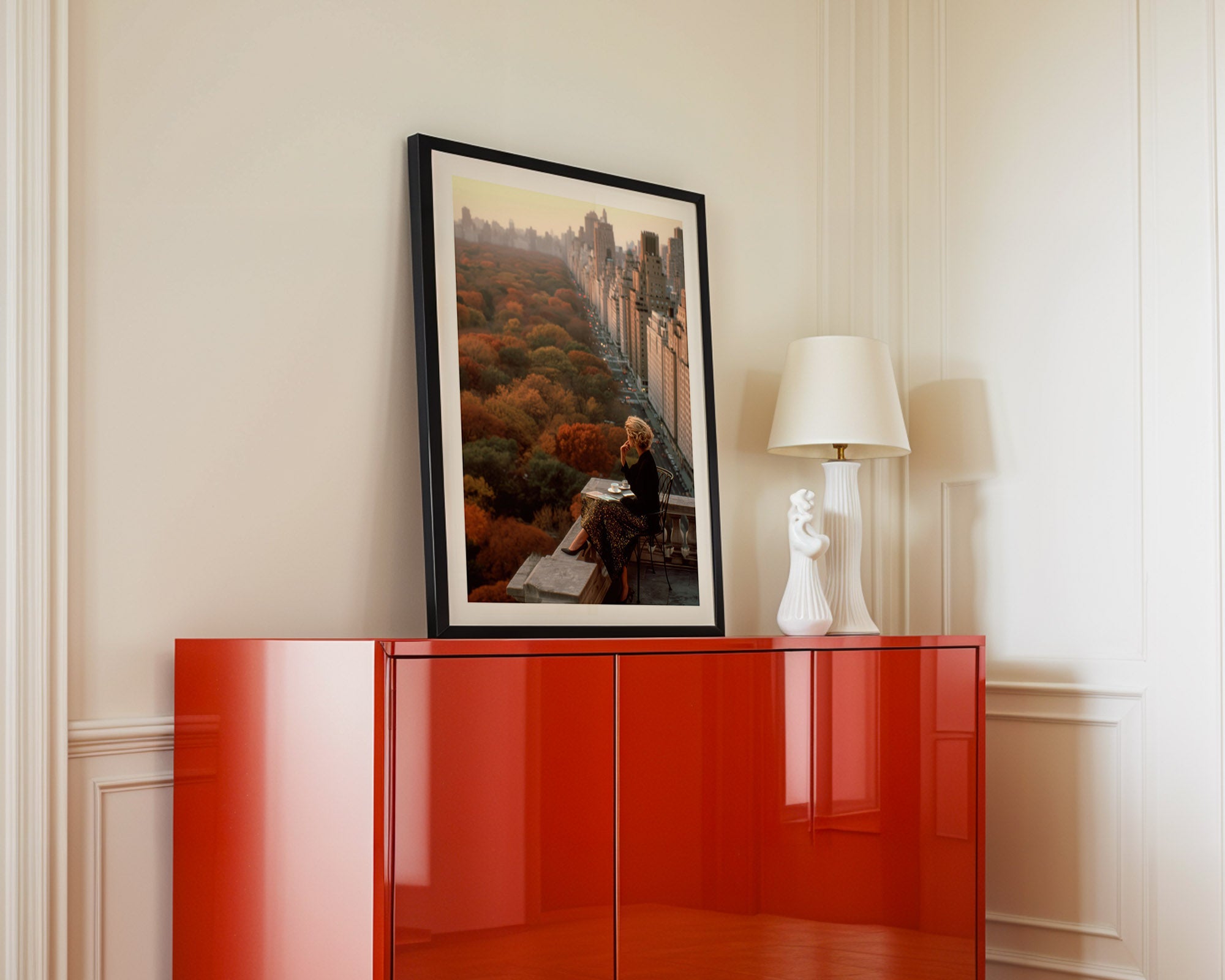 Red cabinet with a framed picture and lamp against a beige wall
