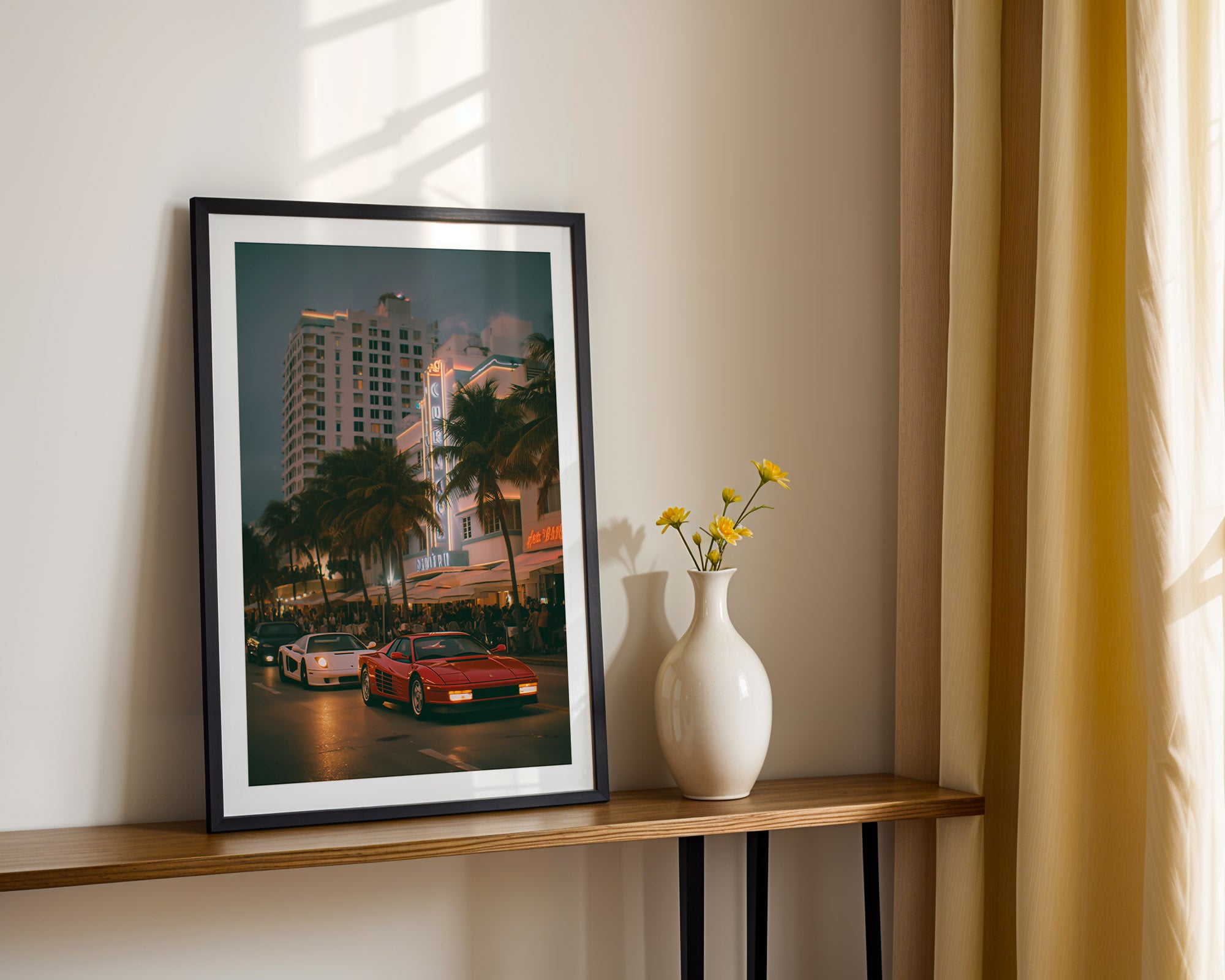 Framed artwork of a city street scene on a wooden shelf with a vase of flowers.