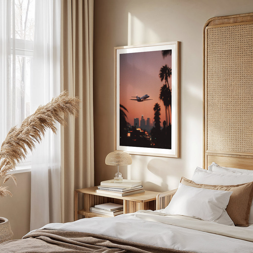 Modern bedroom with a bed, bedside table, and wall art of an airplane over palm trees.