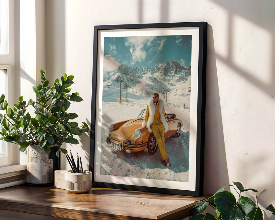 Framed artwork of a person by a vintage car in a snowy landscape on a wooden shelf.