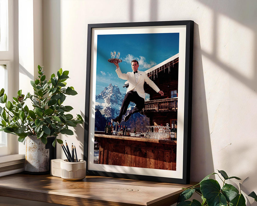Framed artwork of a man in a tuxedo with a mountainous background on a wall.