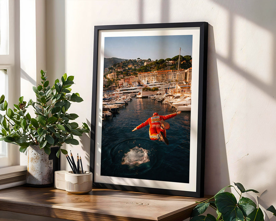 Framed photograph of a person in a red jacket standing on a dock with a scenic view of a coastal town.