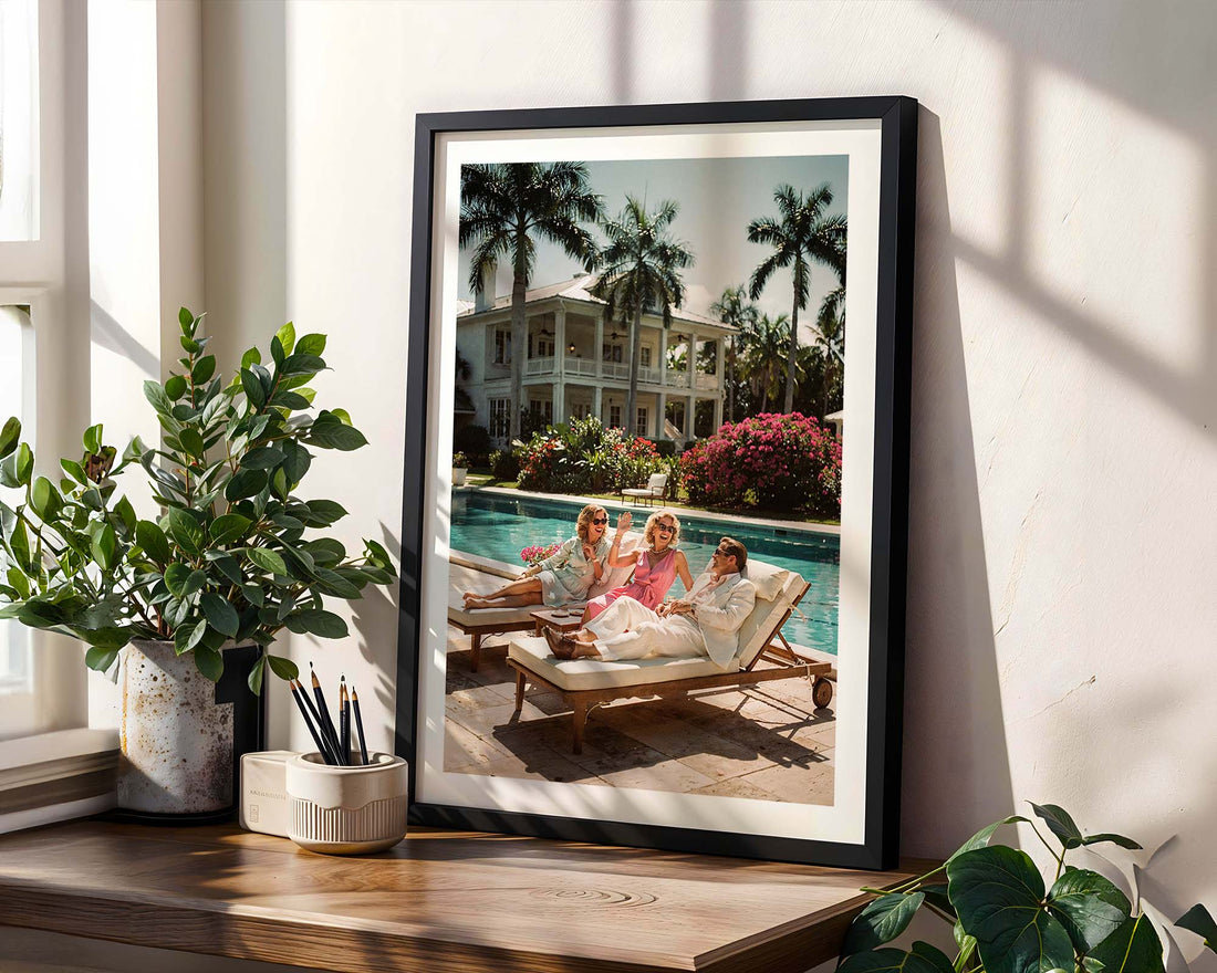Framed photograph of a family by a pool with decorative plants around.