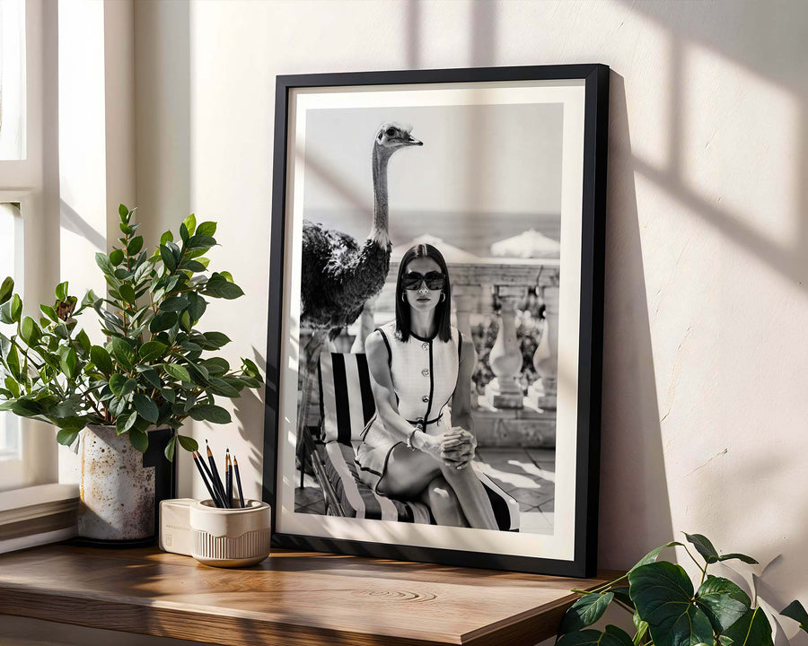Framed black and white photo of a woman on a shelf with plants
