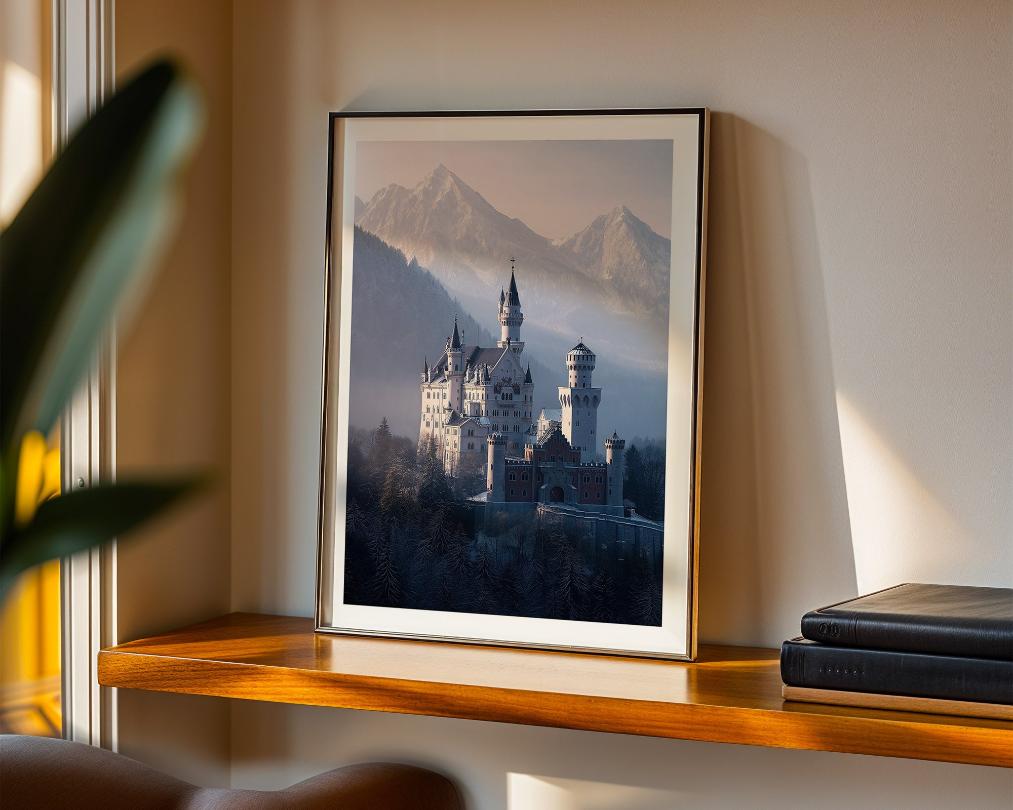 Framed artwork of a castle with mountains on a wooden shelf.