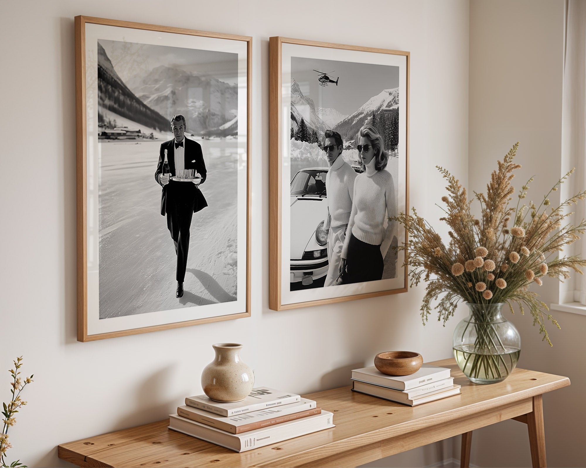 Two framed black and white photos on a wall above a wooden console table with decorative items.