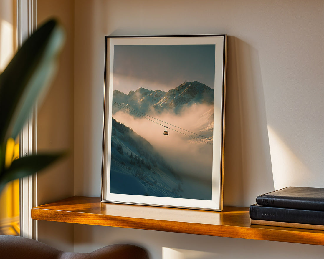 Framed mountain landscape print on a shelf with books and a plant.