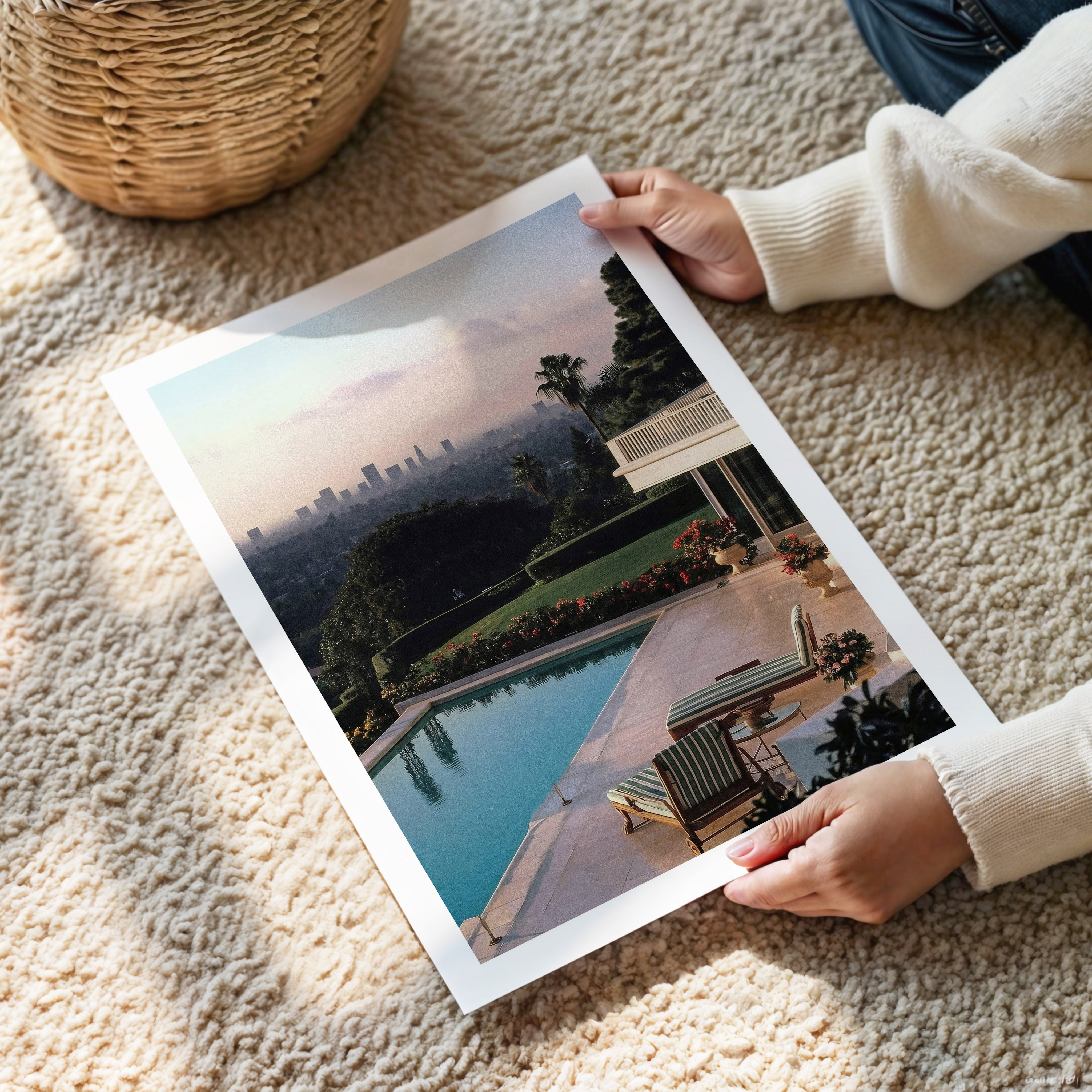 Person holding a large photo of a scenic landscape in Los Angeles on a carpeted floor