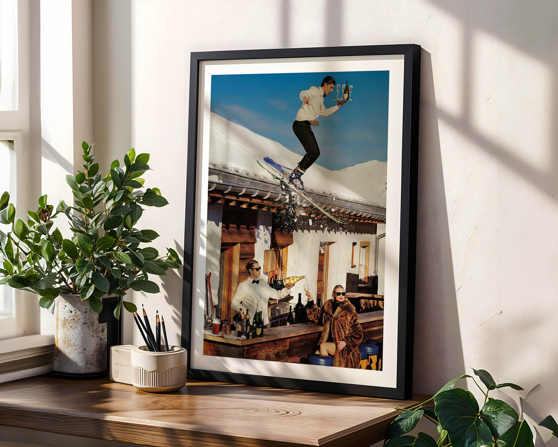 Framed photograph of a person on skiis in the Swiss alps in a mountainous setting, displayed on a wooden shelf with plants.