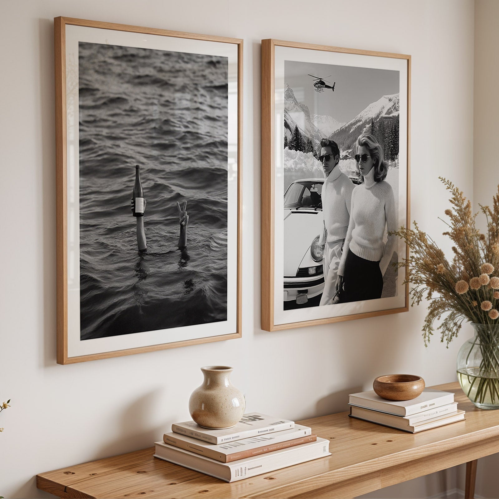 Two framed black and white photographs on a wall above a wooden console table with decorative items.