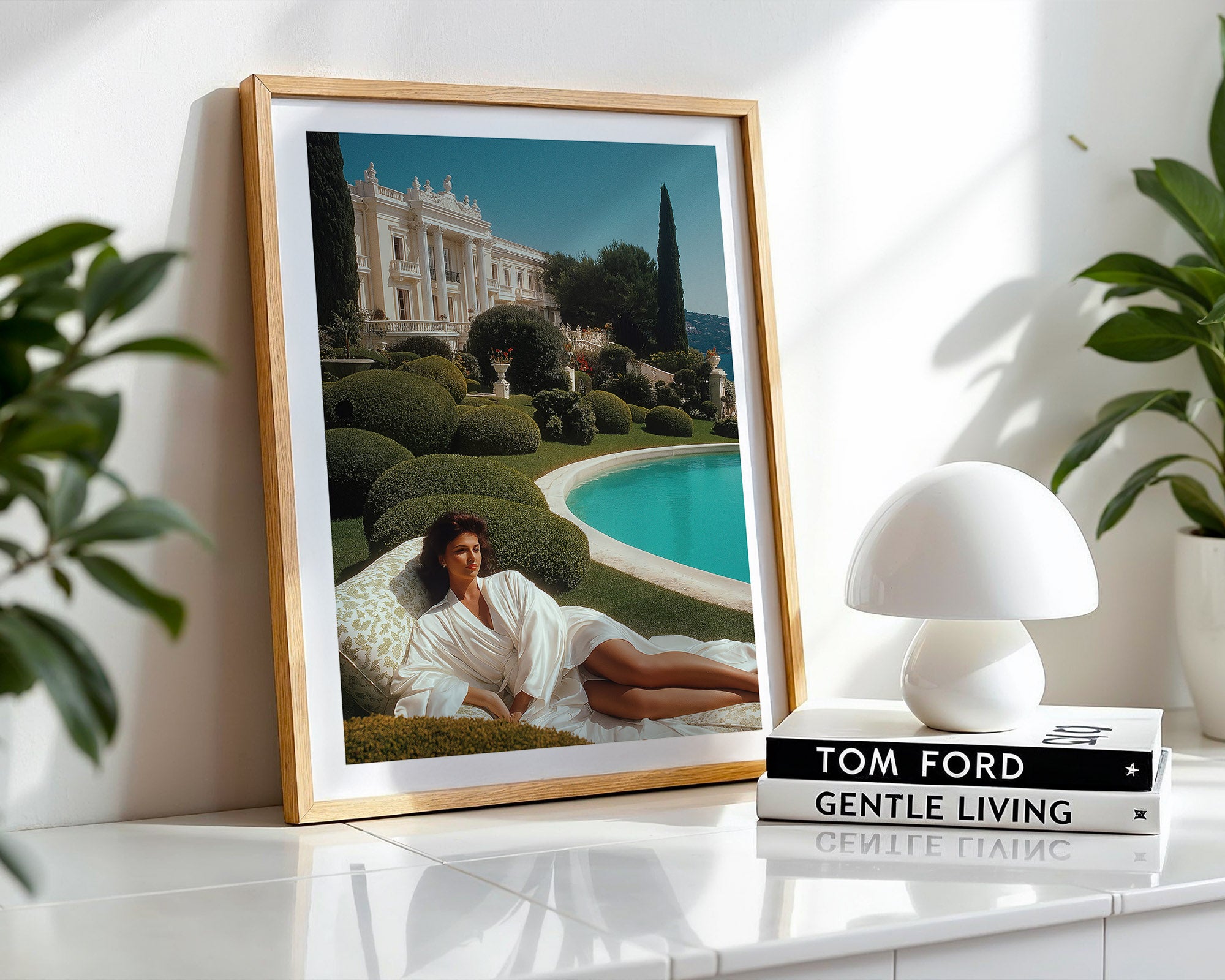 Framed photograph of a woman by a pool with a white lamp and books on a shelf.