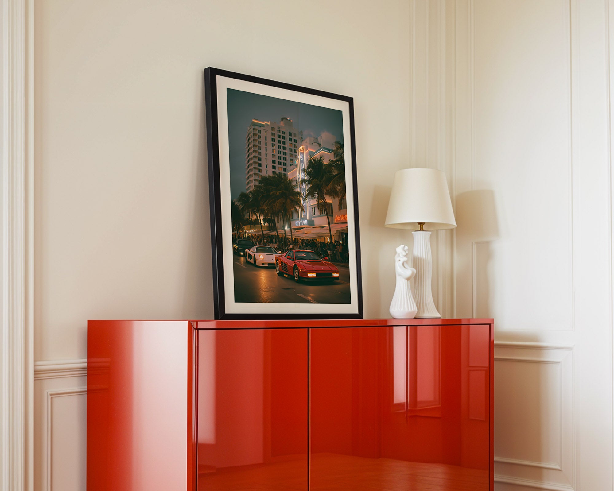 Red cabinet with a framed picture and lamp against a white wall