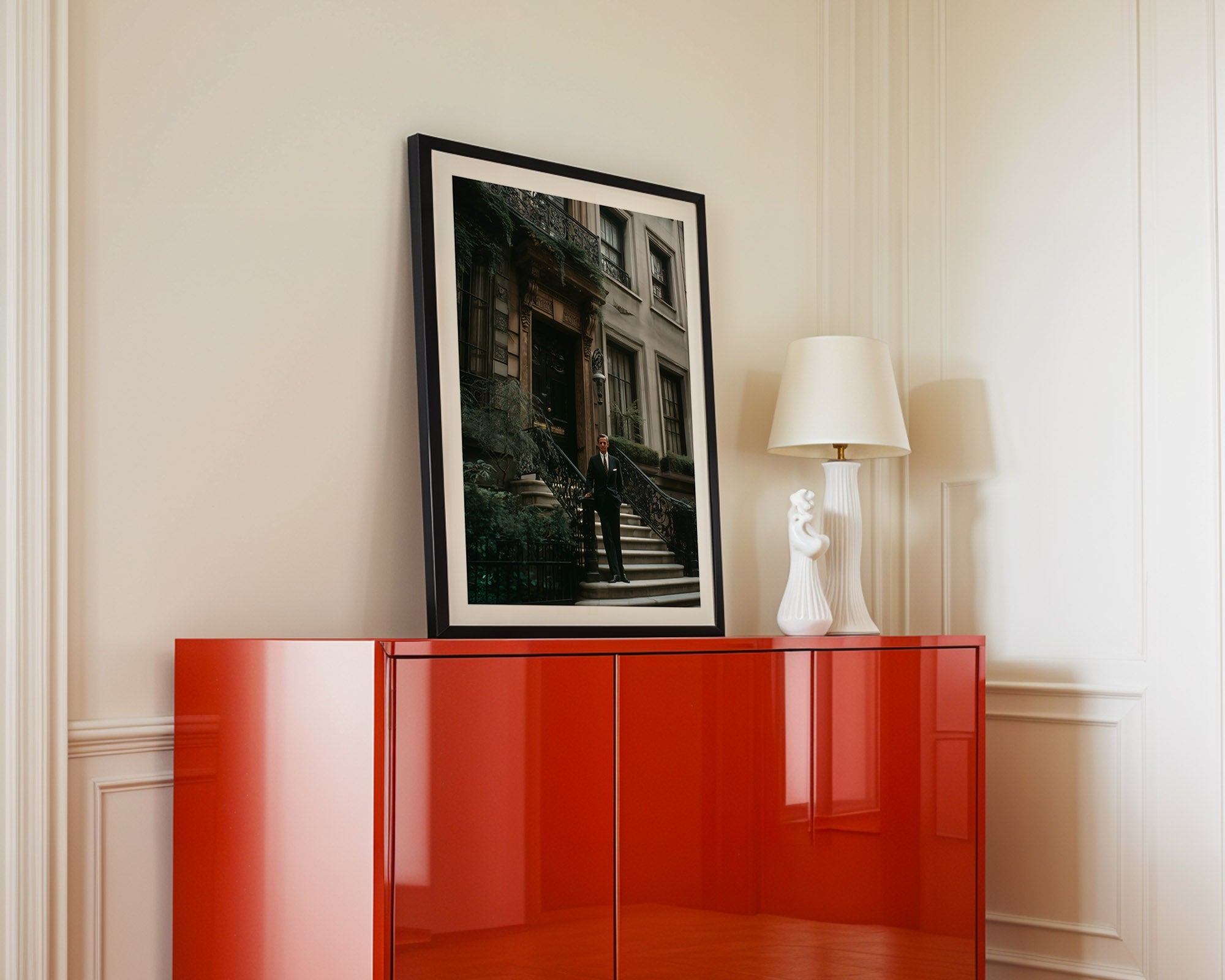 Red cabinet with a framed picture and lamp against a beige wall