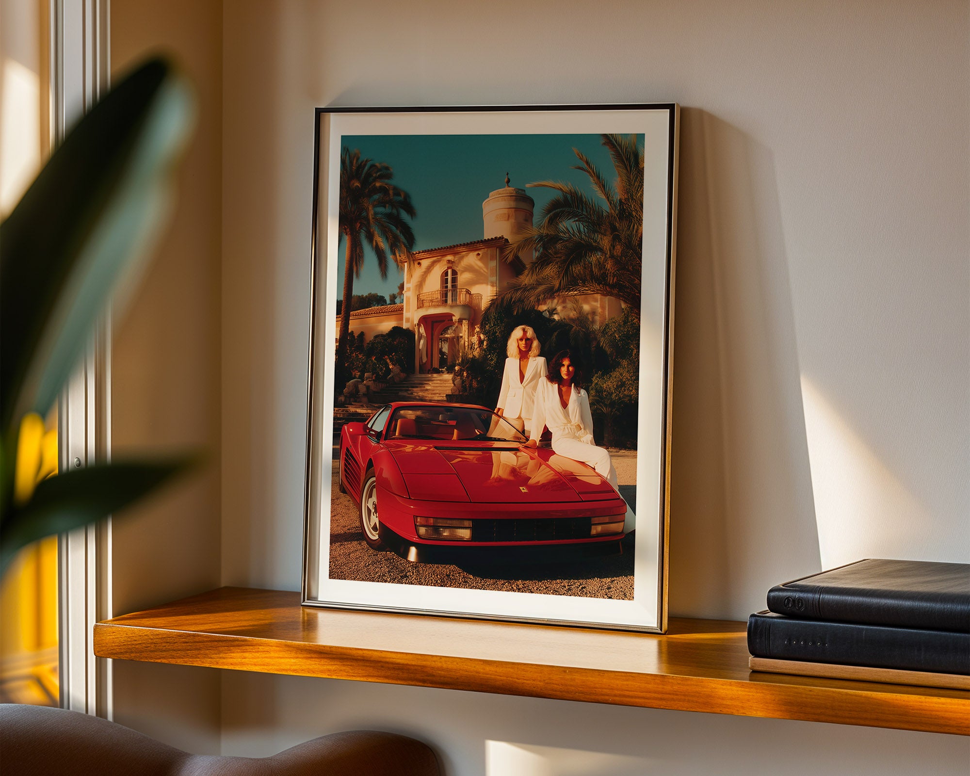 Framed artwork of two woman by a red Ferrari on a wooden shelf.