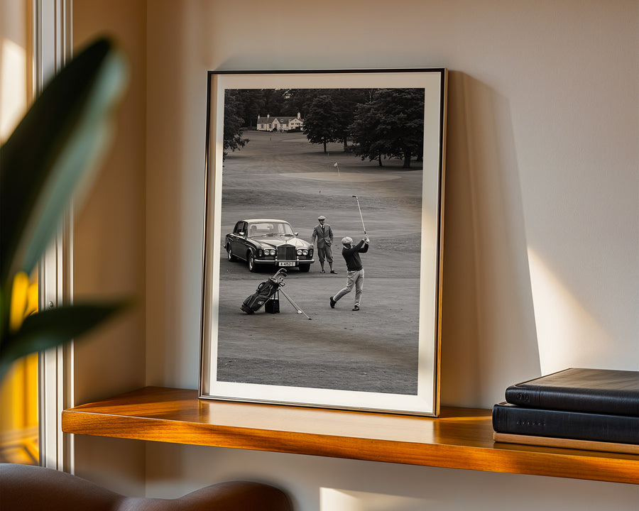 Framed black and white photograph of a golfer on a golf course displayed on a shelf.