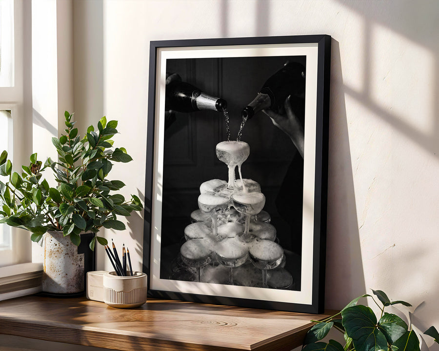 Framed black and white artwork on a wooden shelf with plants