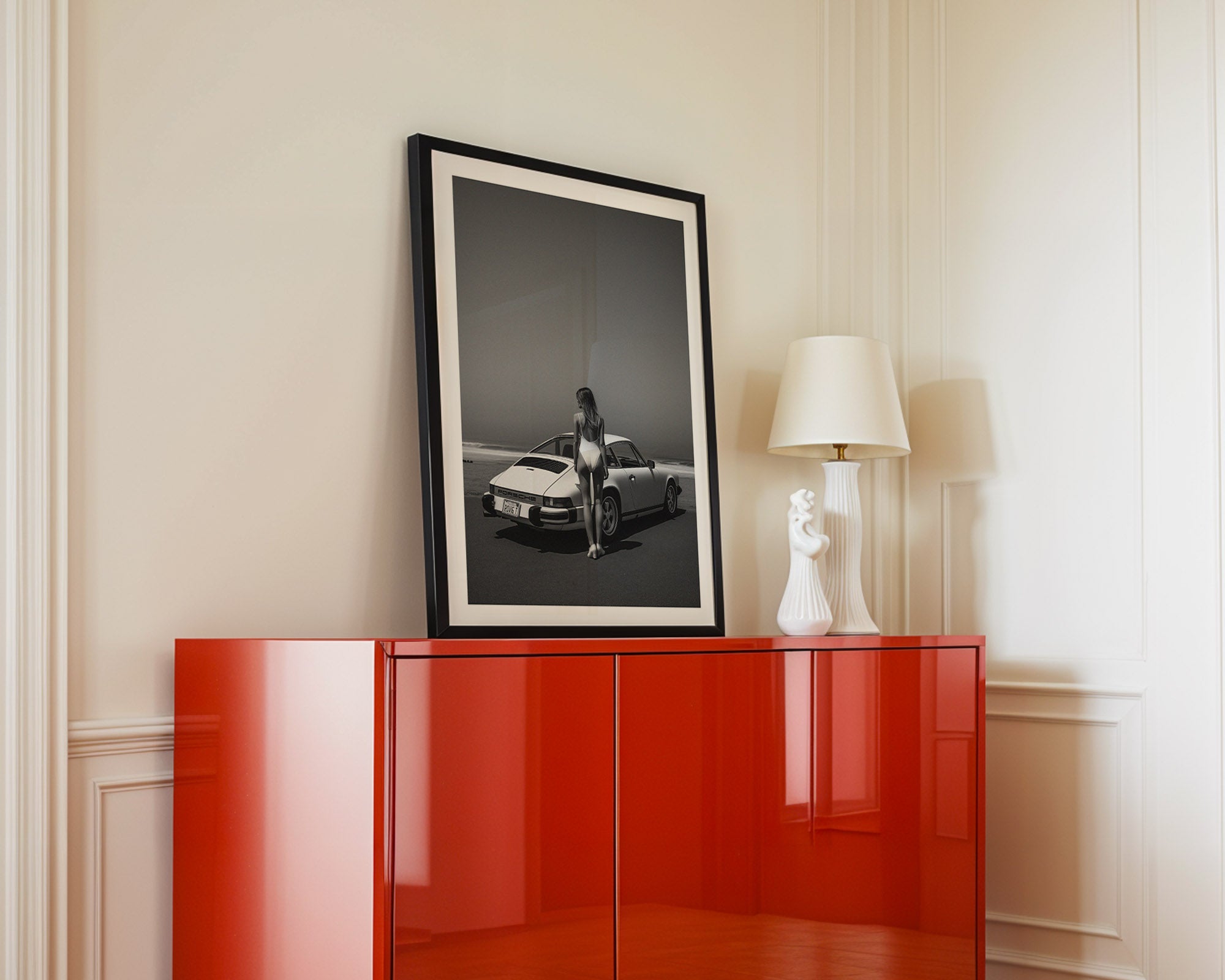 Red cabinet with a framed black and white photograph on a beige wall.