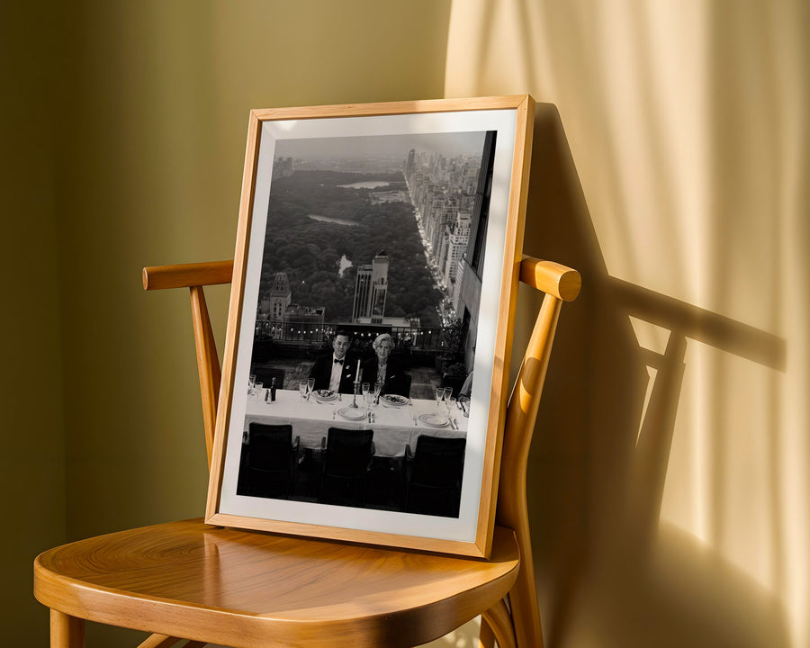 Framed black and white cityscape on a wooden chair with a soft light background