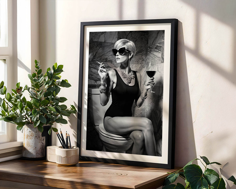 Framed artwork of a woman sitting on a toilet with plants and decor around.