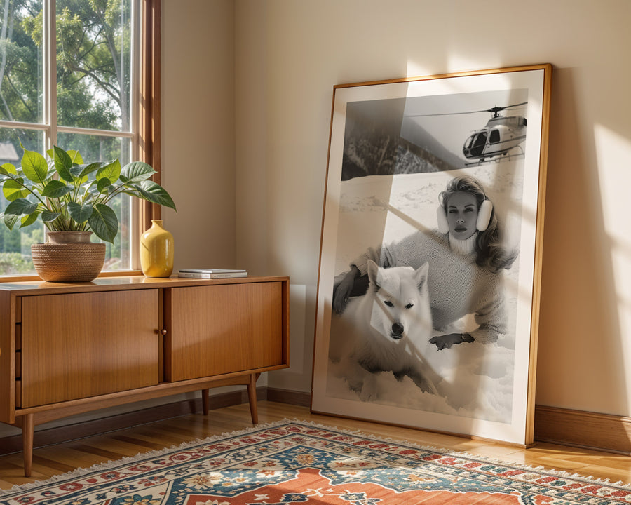 Framed photograph of a woman with a dog on a wall in a room with a wooden sideboard and decorative rug.