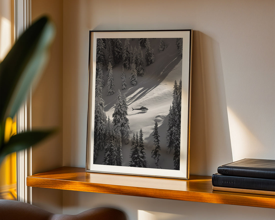 Framed photograph of a snowy landscape with trees and a helicopter on a wooden shelf.