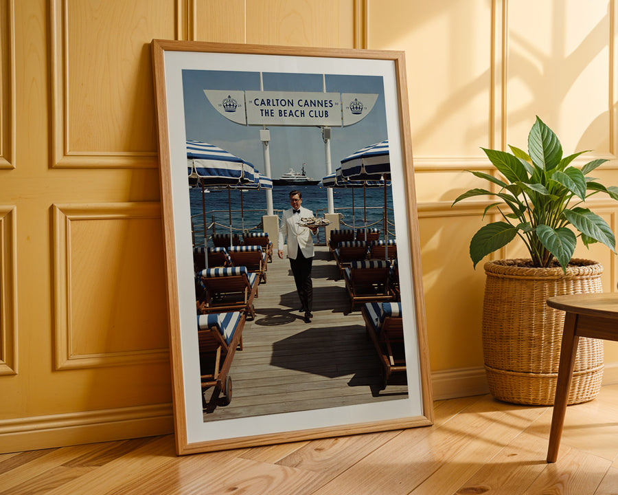 Framed photograph of a man on a dock with boats in the background, leaning against a wooden wall.