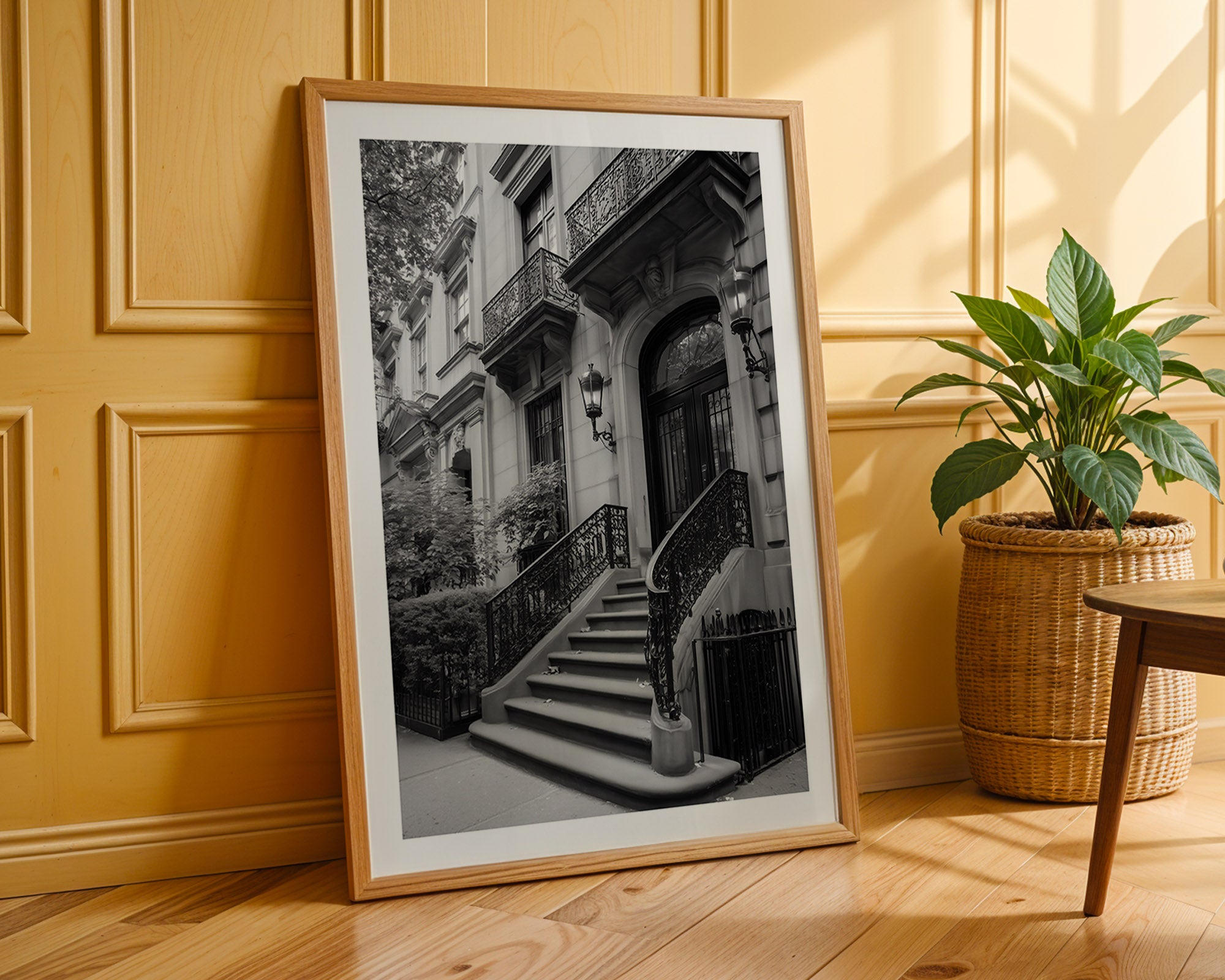 Framed black and white photo of a staircase against a yellow paneled wall.