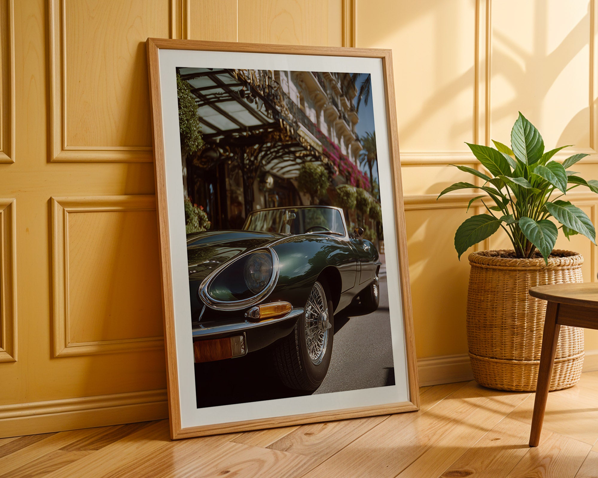 Framed photograph of a classic Jaguar e-type on a wooden floor with a plant in the background