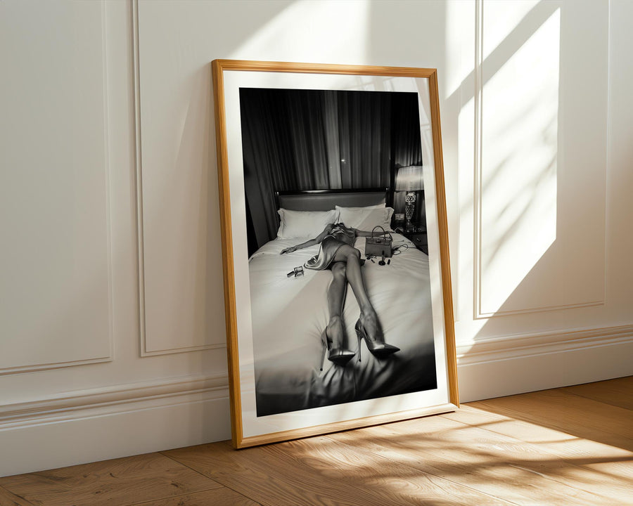 Framed black and white artwork of a woman on a bed in a room with sunlight streaming through a window.
