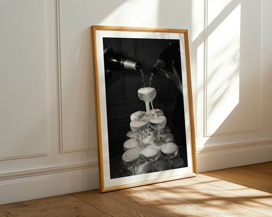 Framed black and white artwork on a wall with sunlight casting shadows.