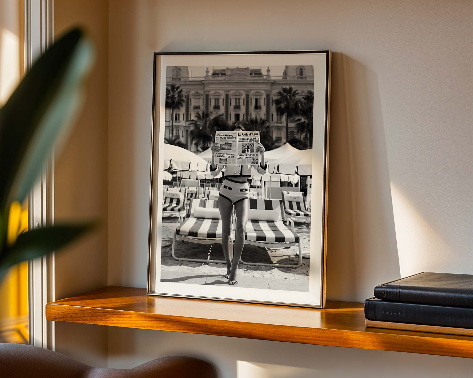 Framed black and white photograph of a person on a beach with lounge chairs.