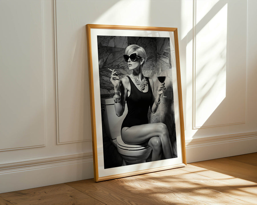 Framed artwork of a woman sitting on a toilet with a stylish pose, held in a sunlit room.