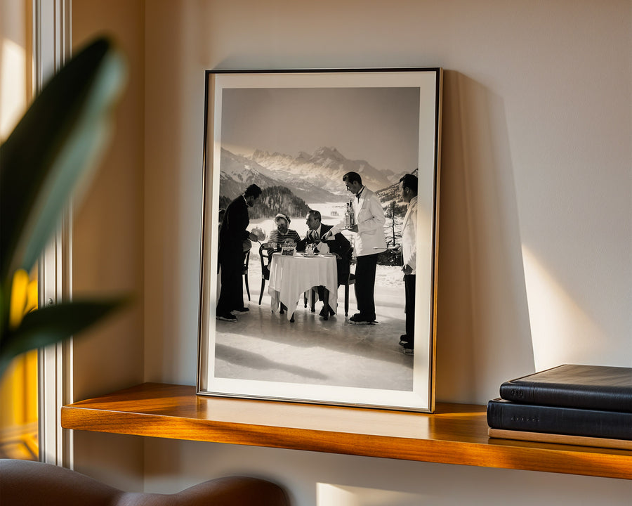 Framed black and white photograph of a snowy mountain scene with people on a shelf.